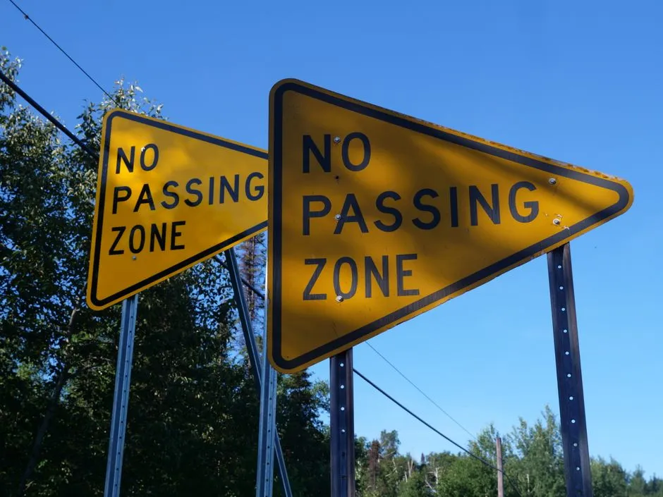Roadside warning and no-passing-zone signs along a rural highway